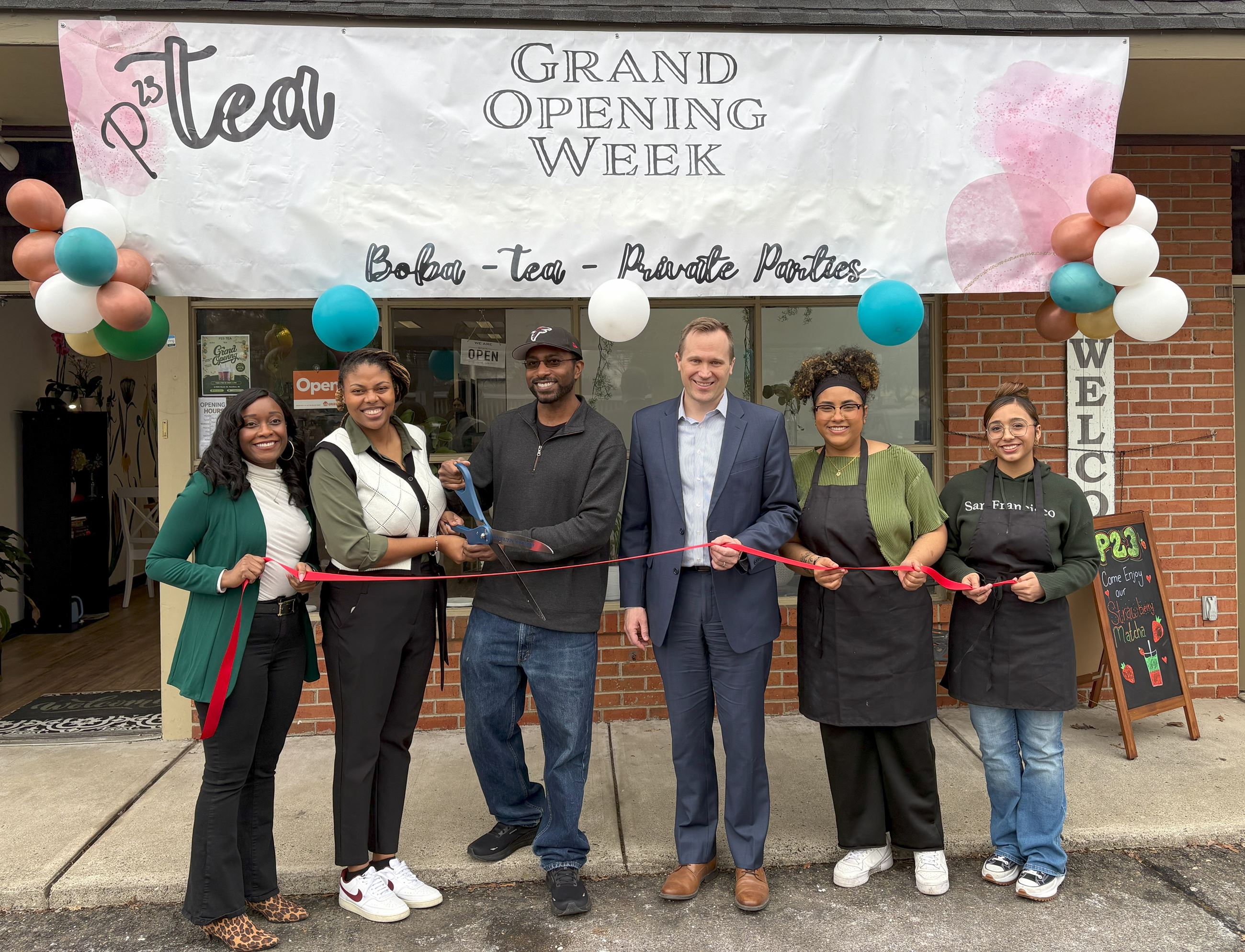 Group of people in front of P23 Grand Opening sign